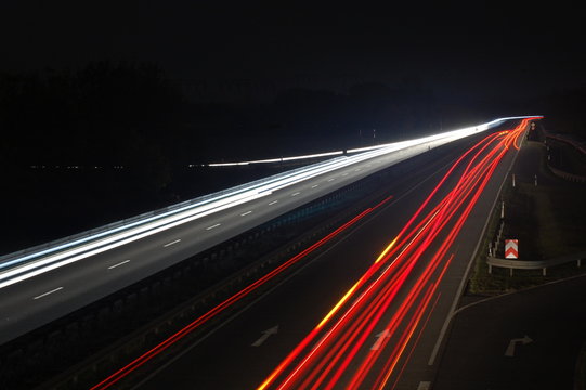road with car traffic at night and blurry lights showing speed
