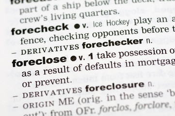A close up of the word foreclose from a dictionary