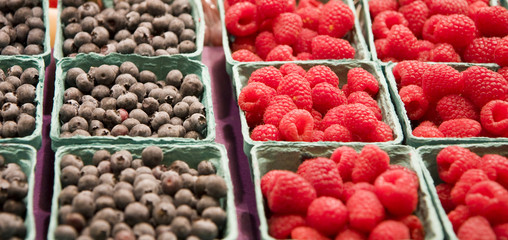Baskets of blueberries and raspberries at a farmers market