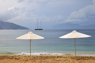 parasols and sailboat near the beach