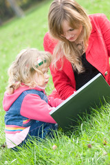 Mom and little daughter with laptop outdoor shot