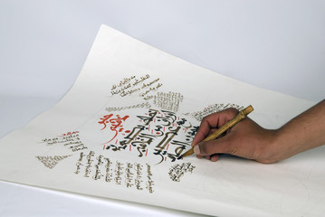 Arabic calligraphy being written by the artist