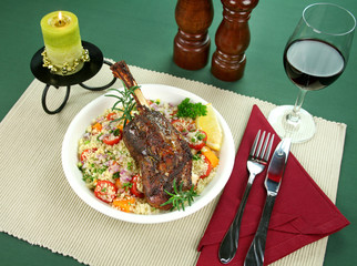 Roasted lamb shank on tomato, butternut and cous cous.