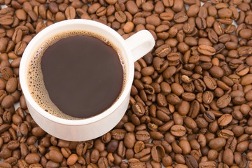 coffee cup with  shaped coffee beans in the background