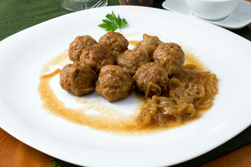 white platter with meat balls on onions sauce