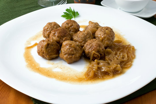 white platter with meat balls on onions sauce