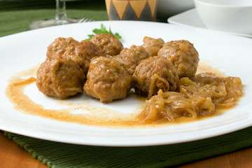 white platter with meat balls on onions sauce