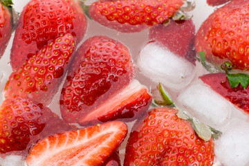 Viele ganze und halbe Erdbeeren im Wasser