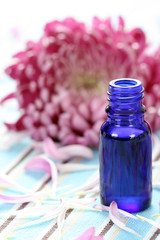 bottle of essential aromatic oil and flower petals