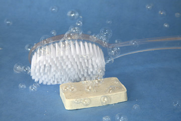 bath brush and soap covered in bubbles