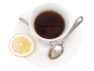 white cup of tea with lemon and spoon in it