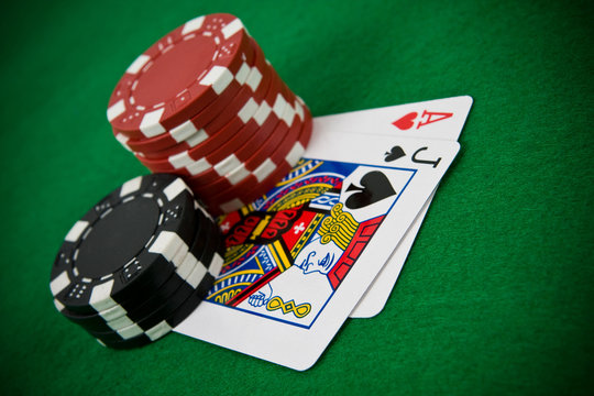 Ace of hearts and black jack with stack of poker chips