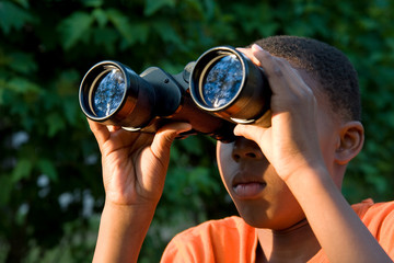 boy looking through binoculars - searching trees