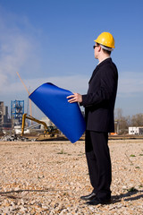 young architect in front of industrial construction site