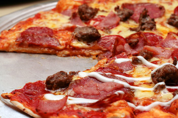 italian all meat flavored pizza with one slice missing.