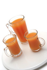 three transparent glasses with orange juice