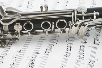 Middle of a clarinet with keys lying across some sheet music