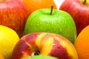 Allsorts from several fruits covered by water drops on a white