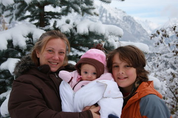maman blonde et ses deux enfants dans un paysage d'hiver