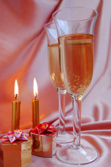 Pair of champagne flutes with candles and gift box