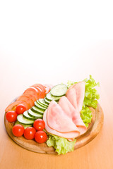 Fresh ham & salad on a wooden plate