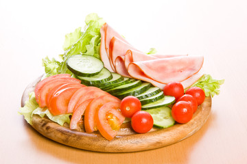 Fresh ham & salad on a wooden plate