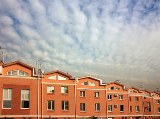 Fototapeta na wymiar A group of townhouses - homes with clouds sky in background