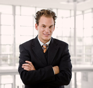 Portrait of happy young businessman smiling at office.