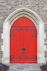 Fototapeta na wymiar Red church doors on a old stone church