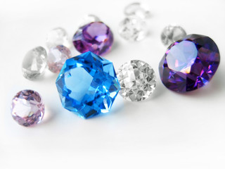 Blue & purple & colorless gems on white background