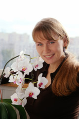 Beautiful young smiling woman with white orchids