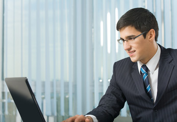 Young businessman working with laptop at office