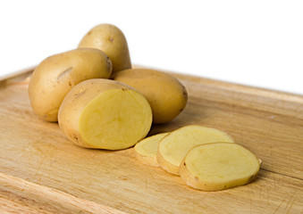 some yellow potatoes on chopping board isolated