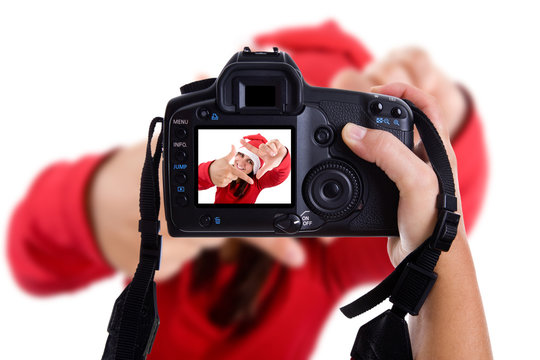 Girl taking photos to a young santa woman in christmas holidays