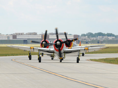 Three propeller airplanes taxiing for takeoff