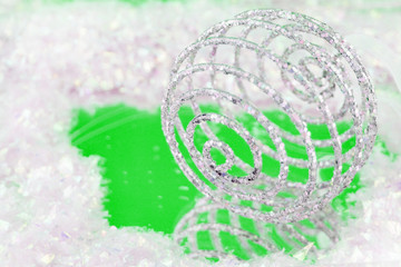 sparkly swirly  christmas ball with reflection on green