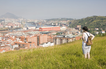 a woman in looking the river or stuary of Bilbao