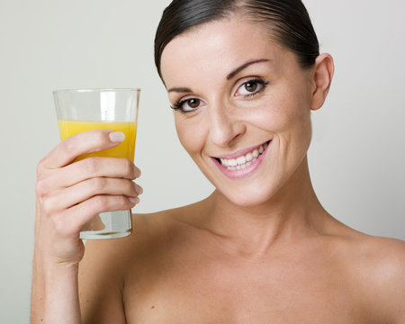 woman holding a glass of orange juice