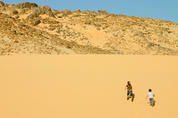 deux enfants escaladant la dune