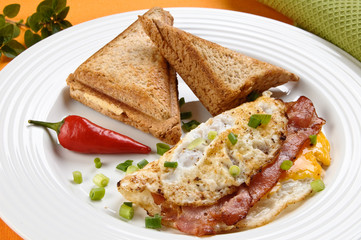 Breakfast - toasts, egg, bacon and vegetables