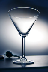 Martini glass sitting on bar with a set of car keys