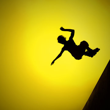 silhouette of roller boy jumping in air