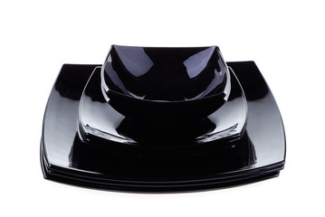 .Stacked black dishes isolated on white background