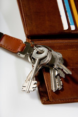 bunch of keys on brown leather wallet