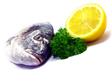 Close-up view of a raw fish with parsley and lemon.