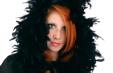 Portrait of the beautiful girl with red hair in a black cape