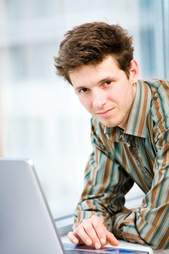 Casual looking happy businessman working on laptop