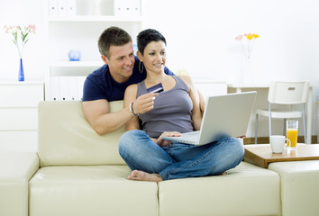 Couple shopping on internet paying by credit card.