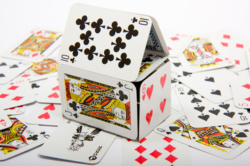 A house made of playing cards sitting on top of other cards
