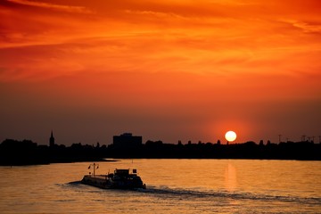 Fototapeta premium Barge with cargo at sunset